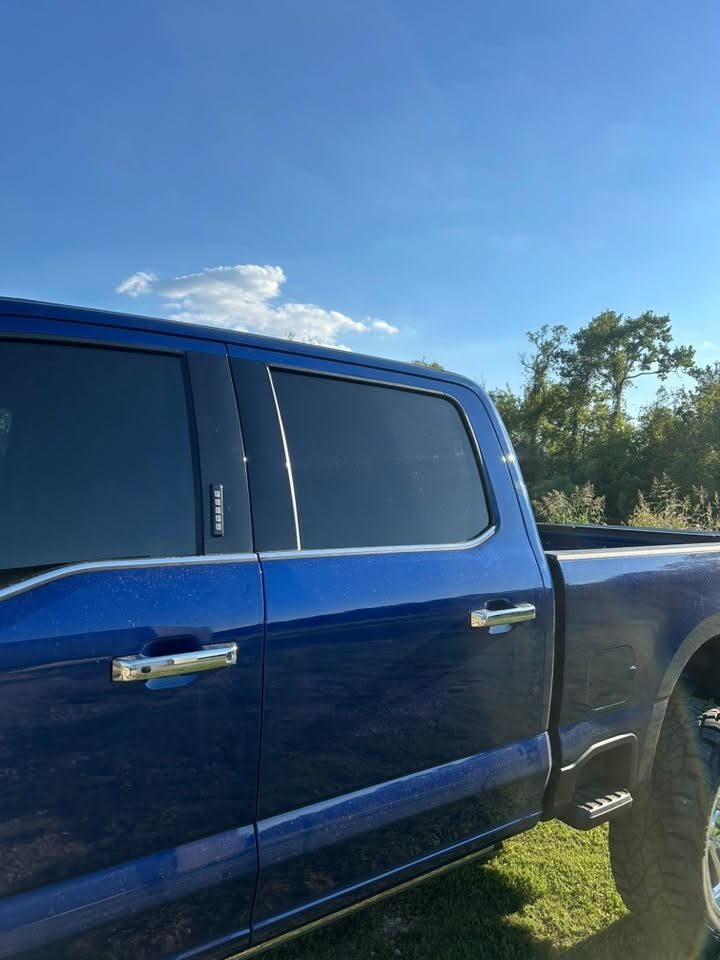A blue crew-cab truck with tinted windows