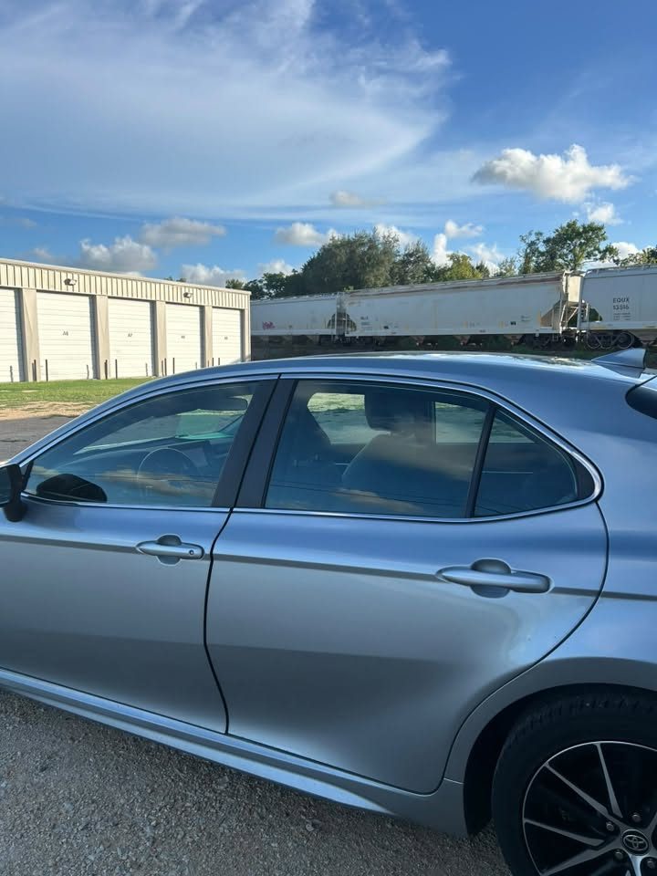 A blue Toyota Camry with tinted windows