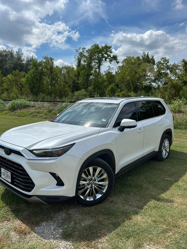 A white Toyota Grand Highlander with tinted windows