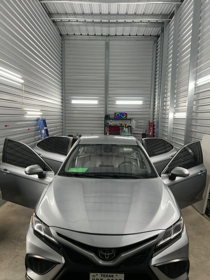 A silver Camry in the Chavez Tint bay with its doors open during an install