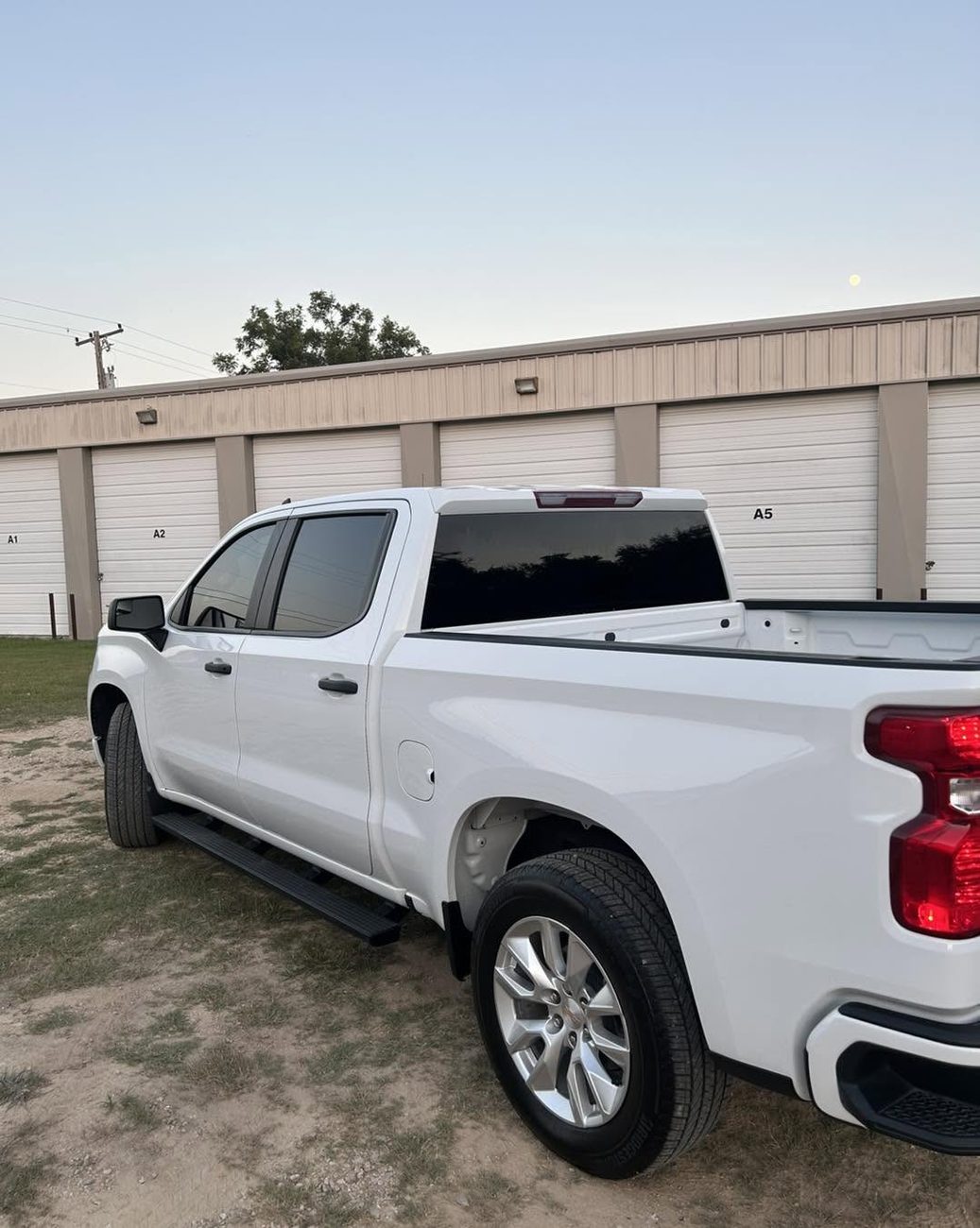A white Silverado with a tinted rear canopy